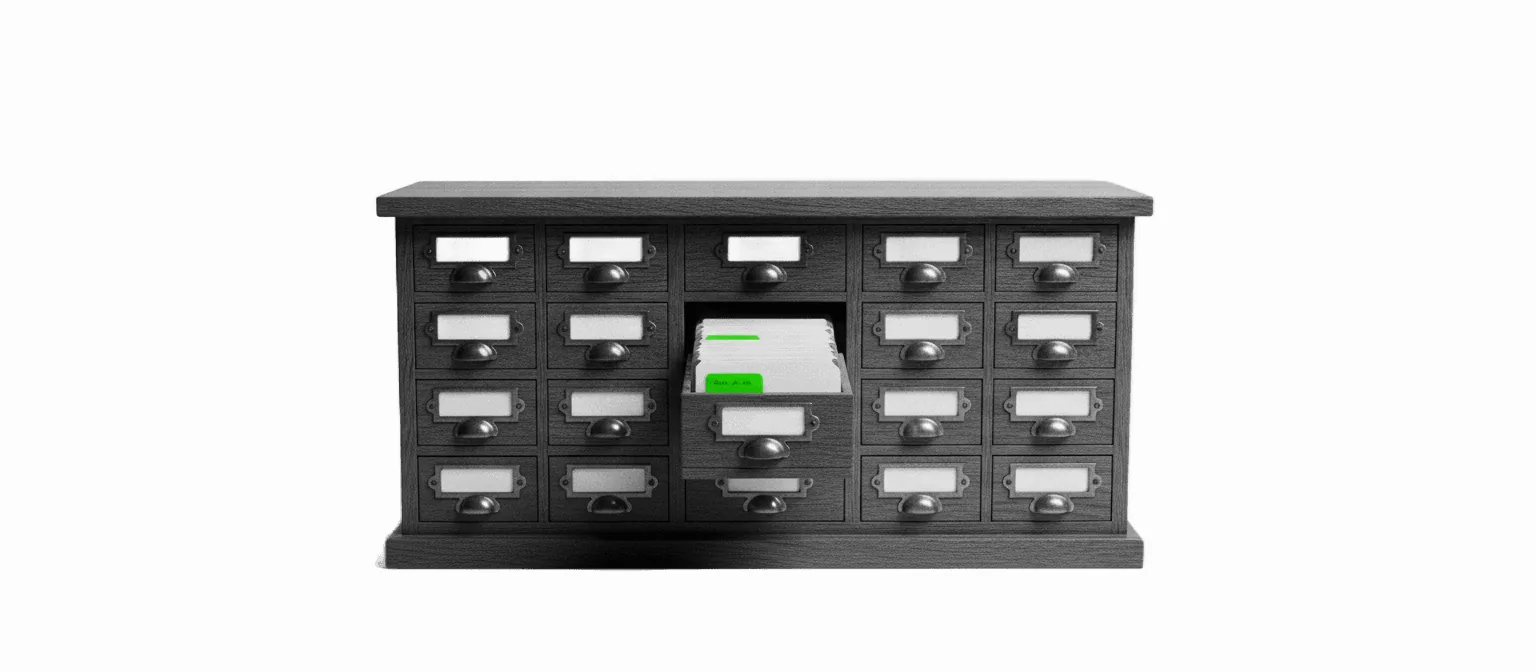 A vintage card-catalog cabinet with one drawer pulled open showing index cards, one tab in vivid green, on a white background