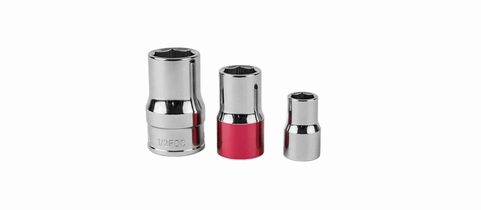A black-and-white photograph of three chrome wrench sockets of different sizes standing in a row on a white background, the middle socket banded in vivid red.