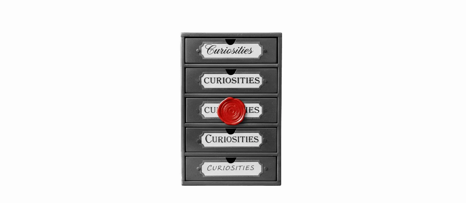 Vintage brass apothecary cabinet with five small drawers, each drawer hand-labeled with the same words in different handwriting, one label sealed with a vivid red wax stamp