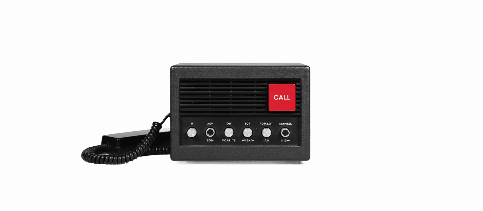 A black-and-white photograph of a 1960s desktop office intercom unit with a single vivid-color labeled call button — the delegate-a-task metaphor for Claude Cowork.
